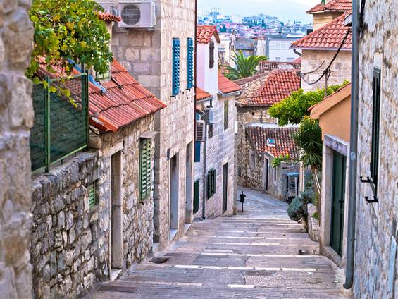 Immobilienkauf Kroatien, Blick eine schmale Gasse entlang, alte Steinhäuser, Foto: xbrchx / iStock
